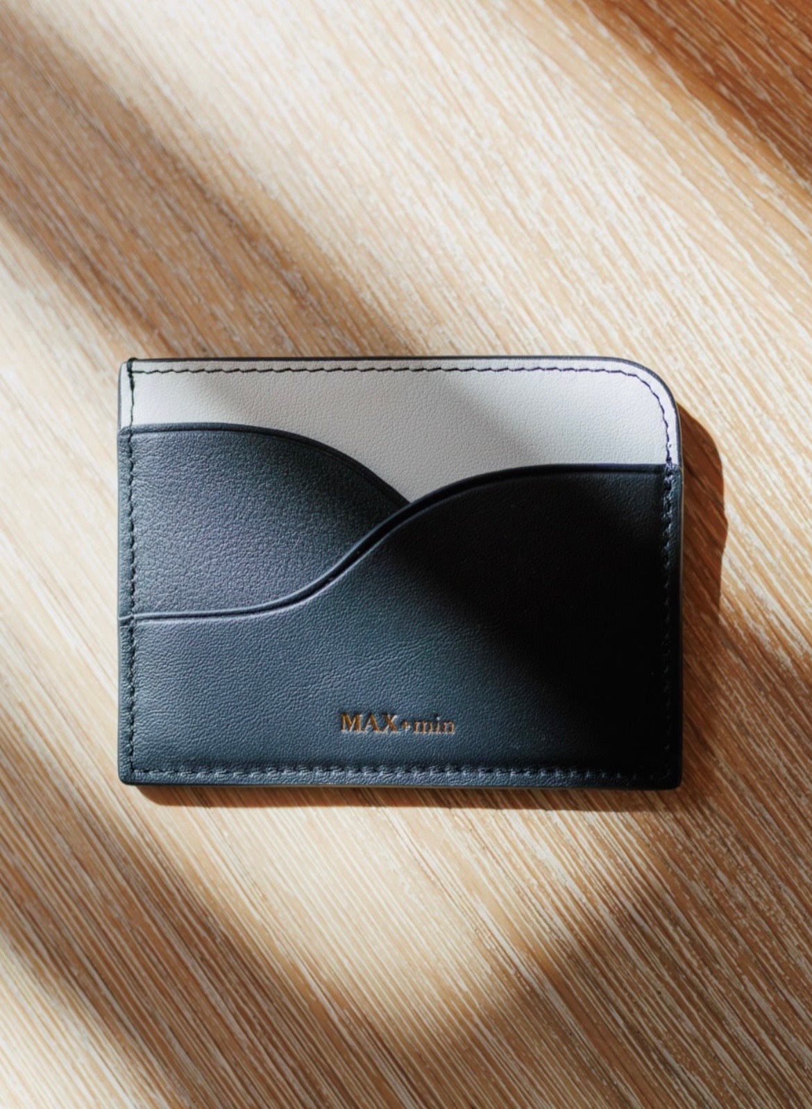 Detail view of the MAX+min black leather card holder.